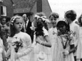 Eerste Communie-optochten in Den Dungen, bij de parochiekerk H. Jacobus de Meerdere, 1971. Het meisje vierde van links is Maureen van Ommen.<br />
(Foto collectie Ommen-Douwes 11, Historisch Beeldarchief Migranten (HBM), IISG, Amsterdam)